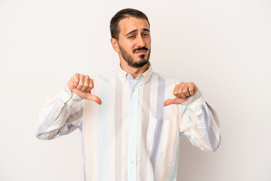 Young caucasian man isolated on white background showing thumb down, disappointment concept.