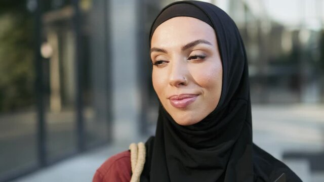 Smiling Muslim woman looking at the camera outdoors