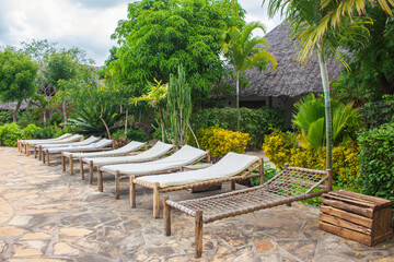Empty lounge chairs on ocean coast. Tourist resort on quarantine. Lounge chair near pool. Tropical resort landscape. Outdoor leisure furniture. Recreation concept. Travel and vacation in Africa. 