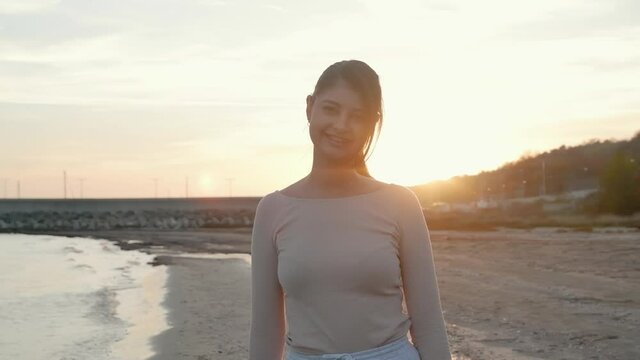 rejoicing and smiling young girl on the beach, sunset time.