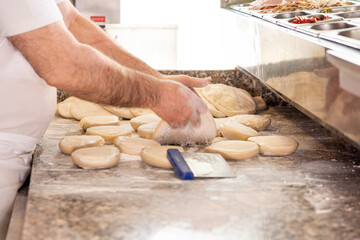 Pizzaiolo impasta la pizza con farina