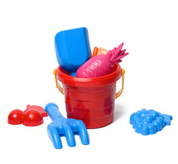 baby red plastic bucket with shovel and toys isolated on white background. Outdoor items