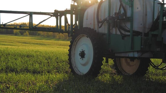 Tractor spraying. Tractor in field spraying crop. Agricultural machinery spraying the crops with pesticides.