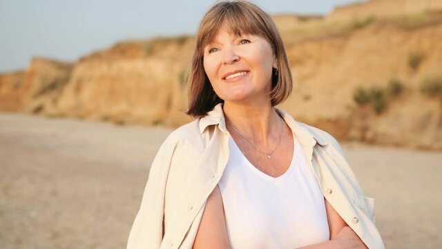 Smiling mature woman looking at the sea on the beach