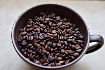Roasted coffee beans in a cup as a close up