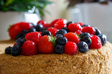 Cake decorated with fresh berries.  Honey cake.
