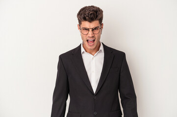 Young business caucasian man wearing headphones isolated on white background screaming very angry and aggressive.