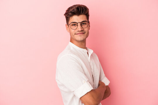 Young caucasian man isolated on pink background happy, smiling and cheerful.