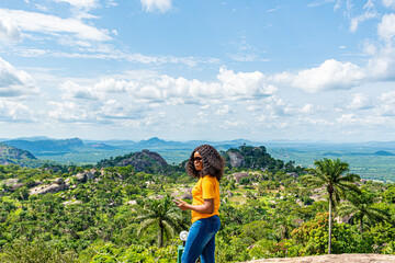 african girl standing against a beautiful nature scenery