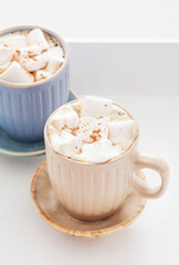 cups of cacao with marshmallows on white wooden tray