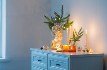 christmas decorations with burning candles in white room