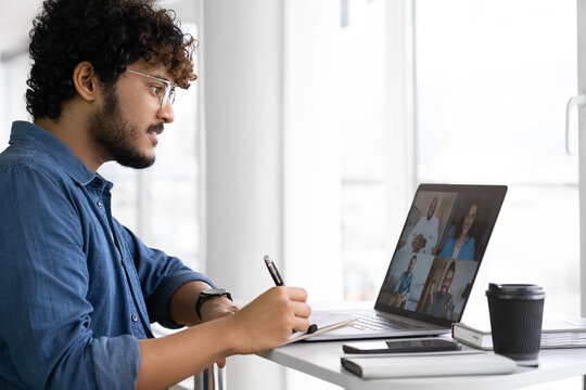 Indian man using app for distance video communication with coworkers via laptop