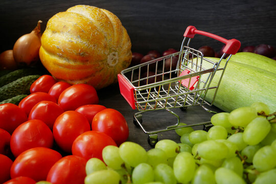 many different fruit and vegetables and Shopping Trolley, green glocery shop, healthy fresh colored fruits and vegetables background delivery