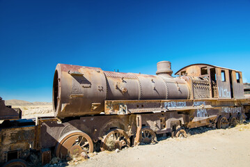 Rusty old steam train in Bolivian desert - train cemetery in Uyuni