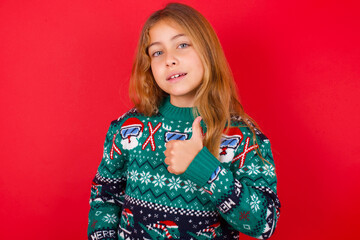 brunette kid girl in knitted sweater christmas over red background giving thumb up gesture, good Job! Positive human emotion facial expression body language.