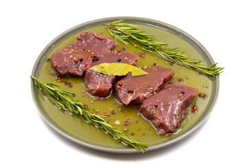Marinated beef tenderloin on a white background. Beef tenderloin marinated with olive oil and various spices