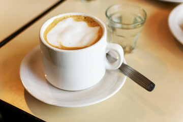 Típico café cortado con leche de bar en taza blanca