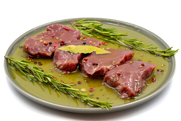 Marinated beef tenderloin on a white background. Beef tenderloin marinated with olive oil and various spices