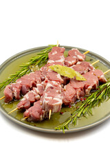 Marinated raw lamb skewers on a white background. Lamb skewers marinated in olive oil and various spices. Story format