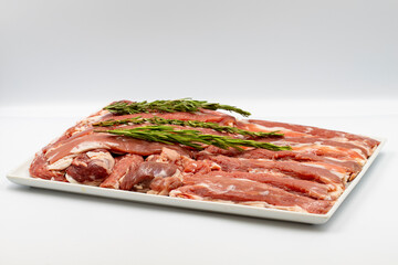 Marinated raw lamb tenderloin on a white background. Lamb tenderloin marinated with olive oil and various spices