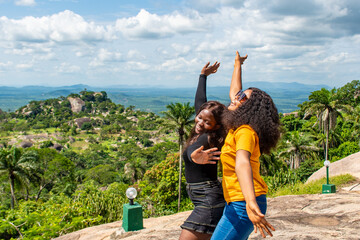 two black girls feeling happy against a natural landscape