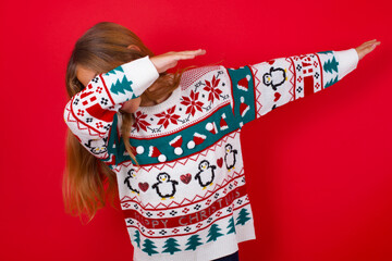 Photo of funky brunette kid girl in knitted sweater christmas over red background show disco move...