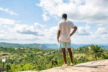young african man staring into a nature landscape