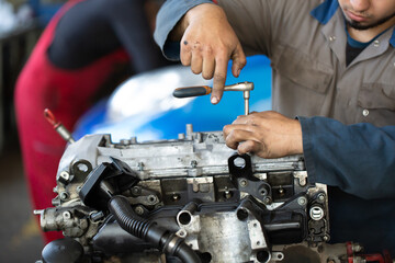 An auto mechanic repairs an internal combustion engine