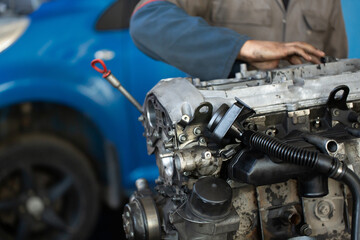 Master, car mechanic repairs the car engine at the service station