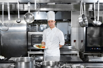 Portrait of a male chef presenting fish dishes