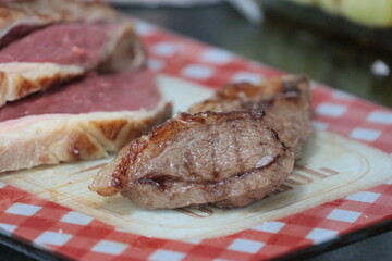 Peça de carne picanha inteira e com cortes crua e grelhada em frigideira