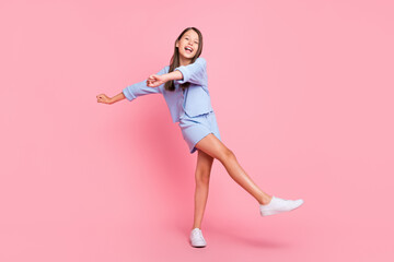 Photo of beautiful funky school girl dressed blue clothes smiling dancing isolated pink color background