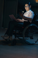 Female with disability working online at home at night