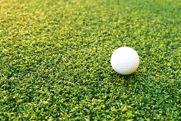 Golf ball close up on green grass on blurred beautiful landscape of golf background.Concept international sport that rely on precision skills for health relaxation..