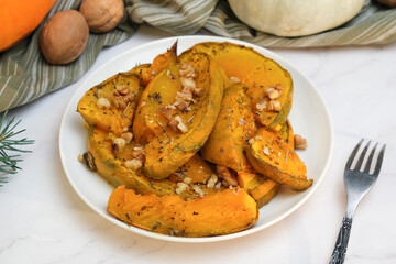 Plate of baked pumpkin with provencal herbs and walnuts. Seasonal autumn Thanksgiving food.