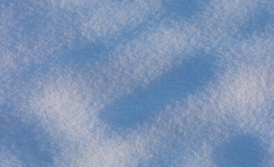 Snow on the ground in the rays of sunset in winter.