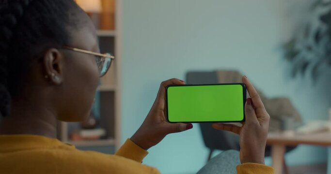 Woman holding green screen mobile in horizontal position