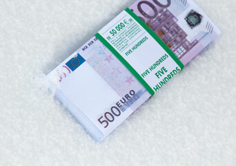Five hundred Euros lie in the snow.