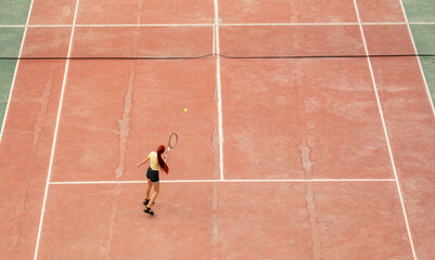 The girl plays tennis on the court. Sport