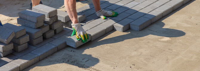 A worker lays paving slabs