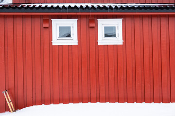 Red fishing house with white window and snow or rorbuer in scandinavia