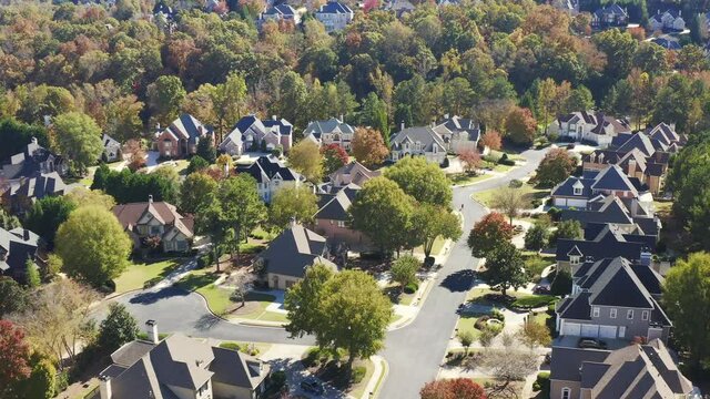 Aerial view of an upscale residential area in a beautiful landscaped houses, autumn tree colors  in Georgia state in Eastern USA shot in 4K during fall of 2021