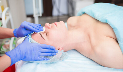 The girl at the beautician makes spa treatments, massage, facial cleansing and a mask for the skin....