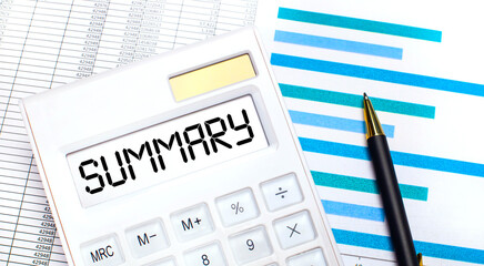 Against the background of reports and blue graphs, a pen and a white calculator with text on the SUMMARY screen. Business concept