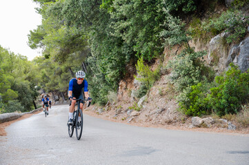 Cyclist in the foreground on a mountain road with another unrecognisable cyclist in the background