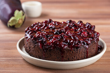 Vegan chocolate cake with berry jam on a wooden table. Sugar, gluten and lactose free.
