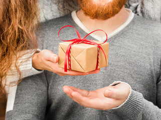 woman's hand gives a gift box to a man close-up