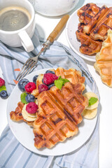 Modern dessert croffle - mixture of croissants and waffles, puff baking waffle iron pan, with berry, fruit cocolate topping