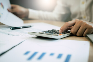 Close up hand of professional accountant review tax paperwork and signing signature on the table in workplace