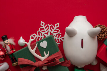 Festive Christmas financial savings concept. White piggy bank money box with presents and...